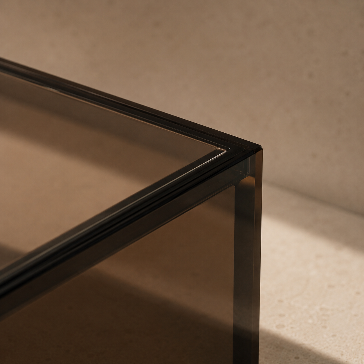 Close-up of a lucite piece corner with a dark smoked transparent glass top and frame, set against a warm beige textured background.